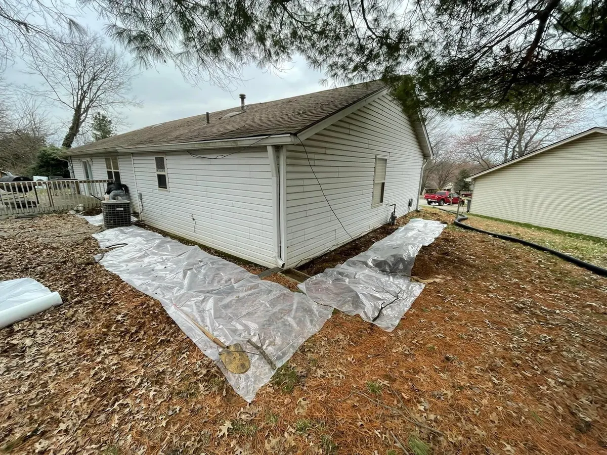 Exterior waterproofing barrier work along a foundation