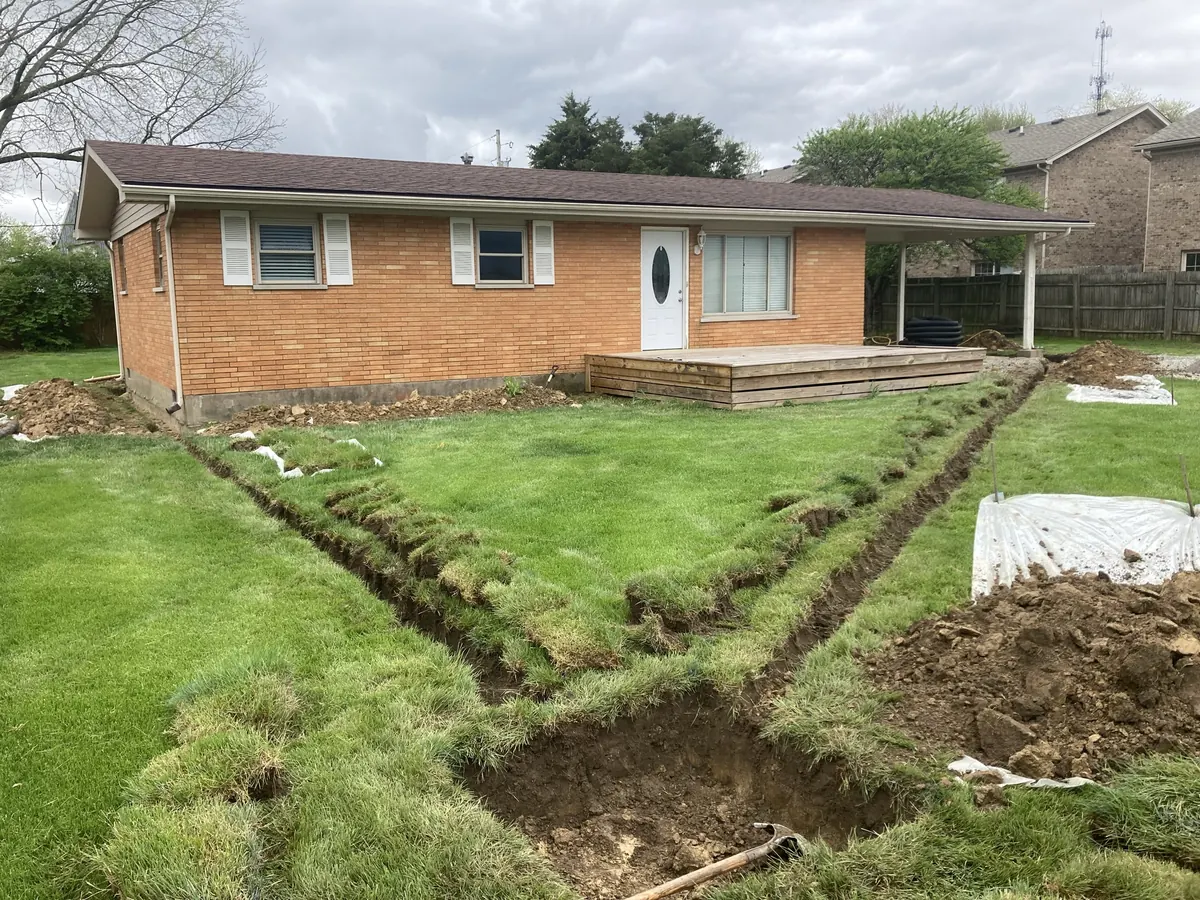 Exterior drainage trench being installed near a home